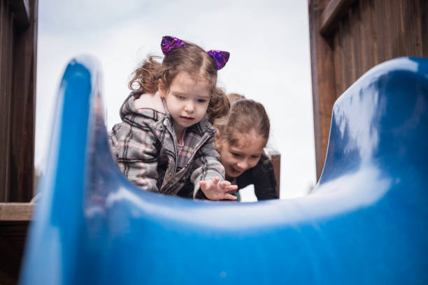istock Girls on playground slide 1216207013