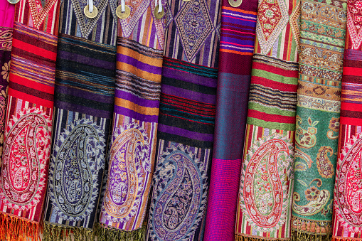 Stack of colorful, traditional Peruvian fabrics. Tourist's market in Chinchero village, Sacred Valley, Peru.The Sacred Valley of the Incas or Urubamba Valley is a valley in the Andes  of Peru, close to the Inca capital of Cusco and below the ancient sacred city of Machu Picchu. The valley is generally understood to include everything between Pisac  and Ollantaytambo, parallel to the Urubamba River, or Vilcanota River or Wilcamayu, as this Sacred river is called when passing through the valley. It is fed by numerous rivers which descend through adjoining valleys and gorges, and contains numerous archaeological remains and villages. The valley was appreciated by the Incas due to its special geographical and climatic qualities. It was one of the empire's main points for the extraction of natural wealth, and the best place for maize production in Peru.http://bem.2be.pl/IS/bolivia_380.jpg