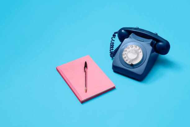 telefone rotativo azul com notebook rosa e caneta - customer service representative on the phone retro revival office - fotografias e filmes do acervo