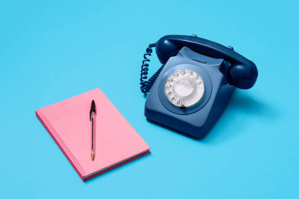 istock Blue vintage rotary phone with pink notebook 1216212473