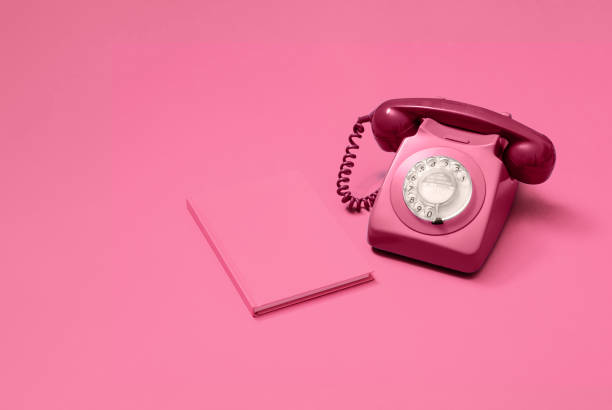 istock Pink rotary phone and notebook on pink 1216212750