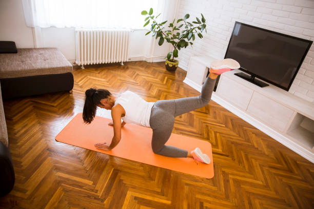 istock Attractive female doing exercise in her living room 1216213149