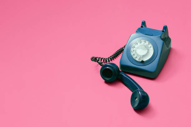 istock Blue rotary phone with lifted handset on pink 1216213343