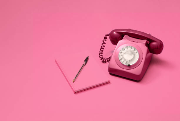 istock Pink rotary phone and pink notebook 1216213468