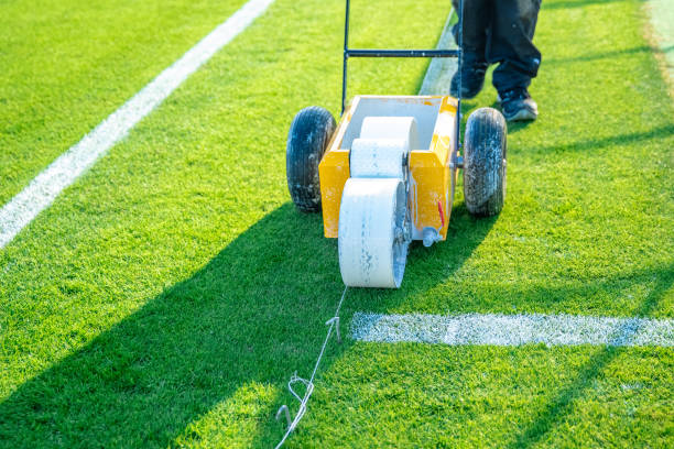 istock drawn white lines on the football field with white paint on the grass using a special machine before a game 1216214839