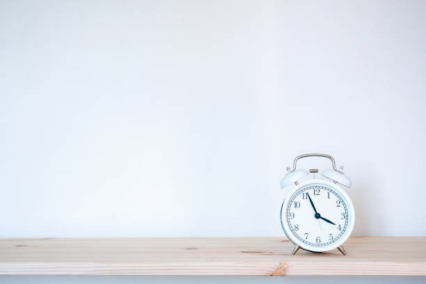 istock White retro alarm clock on brown wood desk 1216215954
