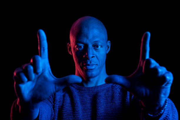 Army veteran activist showing a peace sign. Shoot on a black background with Canon 5D Mark II and developed from 16 bit RAW in Adobe Lightroom/Photoshop.