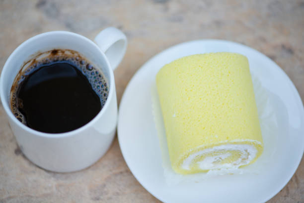 istock Black coffee and Sponge cake cream roll on white dish 1216216417