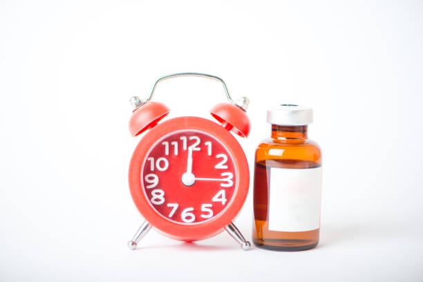 istock Injection vials and red alarm clock show medicine time 1216217636