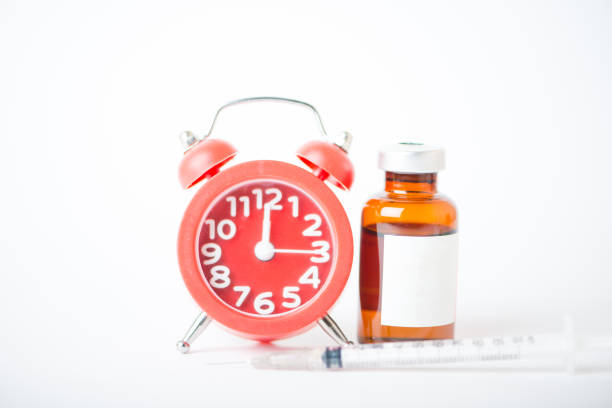 istock Injection vials and red alarm clock show medicine time 1216217666