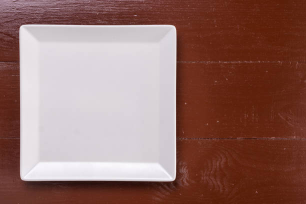 istock Flat lay above white square plate on the wooden brown board table 1216217879