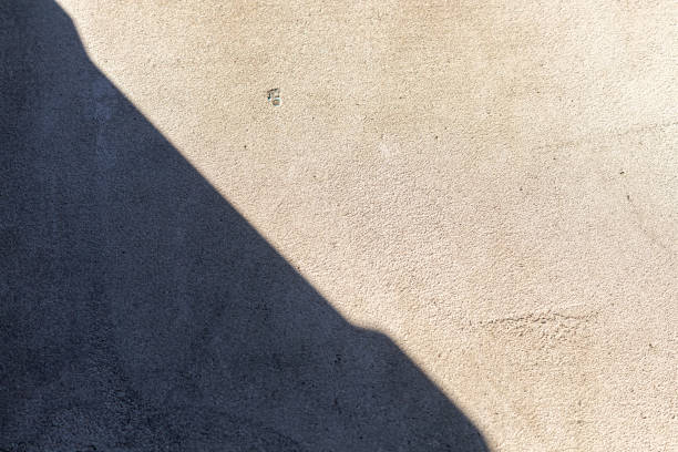 istock Old concrete wall, natural texture. Light background. The shadows. 1216220520