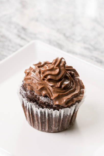 istock Chocolate cup cake with ganache chocolate cream on the white square plate 1216222243
