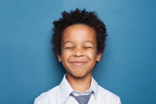 istock Laughing small black child boy student on blue background 1216222304
