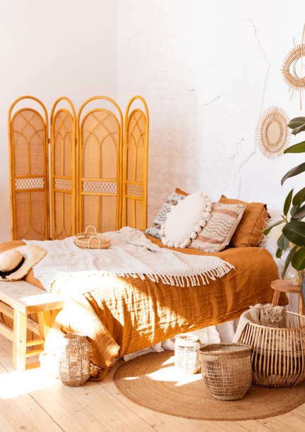 istock Modern boho interior of bedroom with wicker baskets, wooden bench and screen! 1216222461