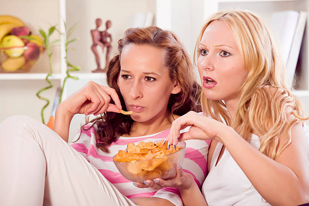 istock two women watching television at home 121622263