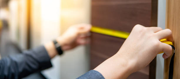 male hand using tape measure on cabinet materials - tape measure home improvement measuring wood imagens e fotografias de stock