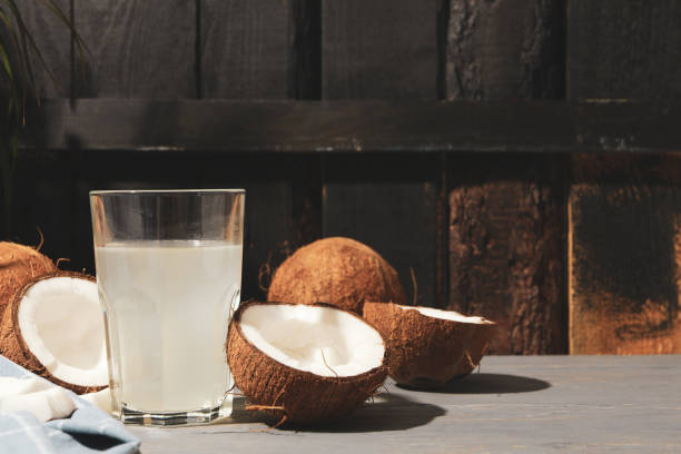 istock Coconut and water on wooden background, space for text. Tropical fruit 1216223404