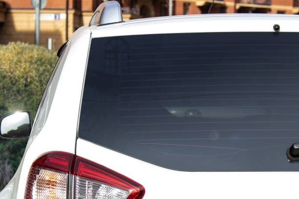 ventana trasera de un coche blanco aparcado en la calle. - vista posterior fotografías e imágenes de stock
