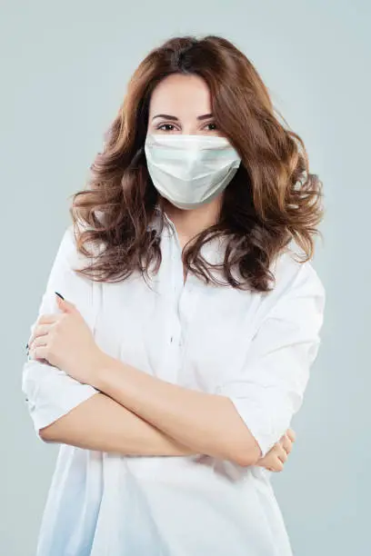 Infectious disease specialist or virologist woman wearing a face mask. Woman in medical mack. Flu epidemic and virus protection concept