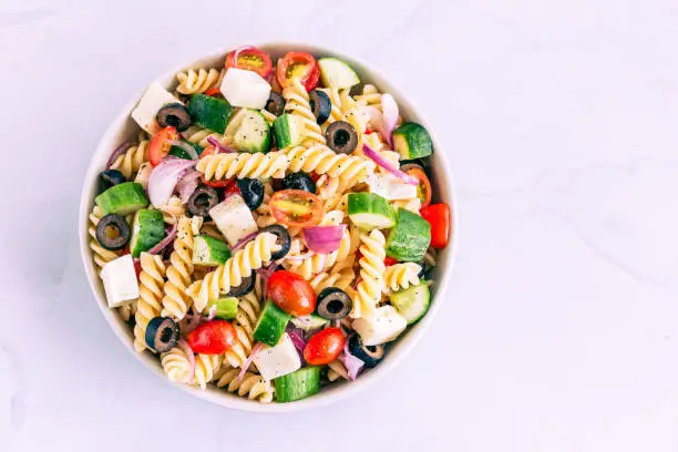 Mediterranean Fusilli Pasta Salad with Tomatoes, Black Olives, Cucumber, Mozzarella Top View Horizontal Photo
