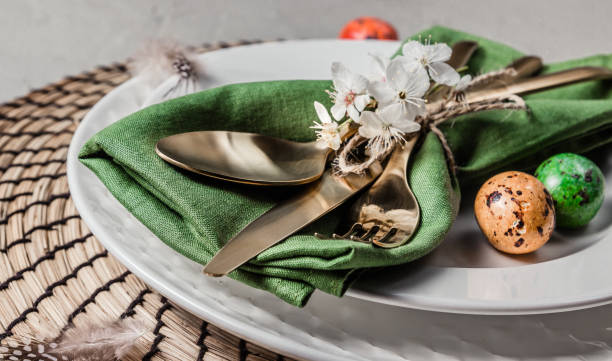 istock Easter table setting. Empty plates with green linen napkin and golden cutlery on concrete background. Top view. Flat lay. Copy space. 1216224071