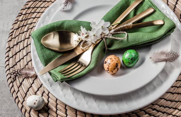 istock Easter table setting. Empty plates with green linen napkin and golden cutlery on concrete background. Top view. Flat lay. Copy space. 1216224080