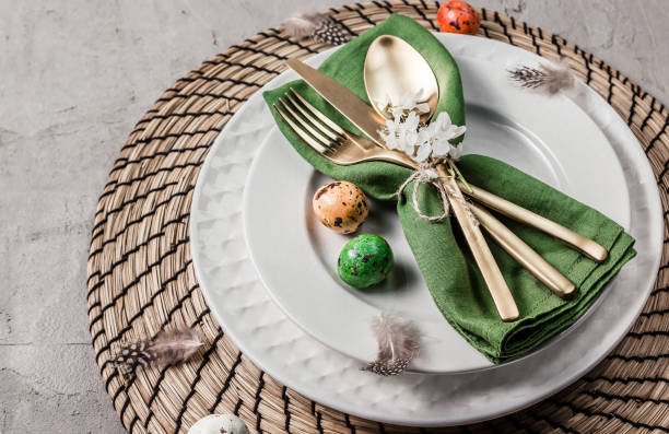 istock Easter table setting. Empty plates with green linen napkin and golden cutlery on concrete background. Top view. Flat lay. Copy space. 1216224085