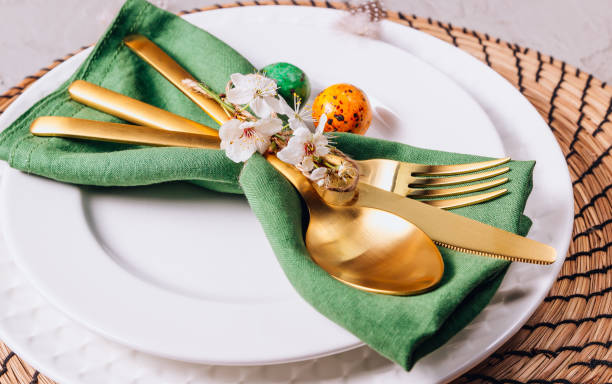 istock Easter table setting. Empty plates with green linen napkin and golden cutlery on concrete background. Top view. Flat lay. Copy space. 1216224093