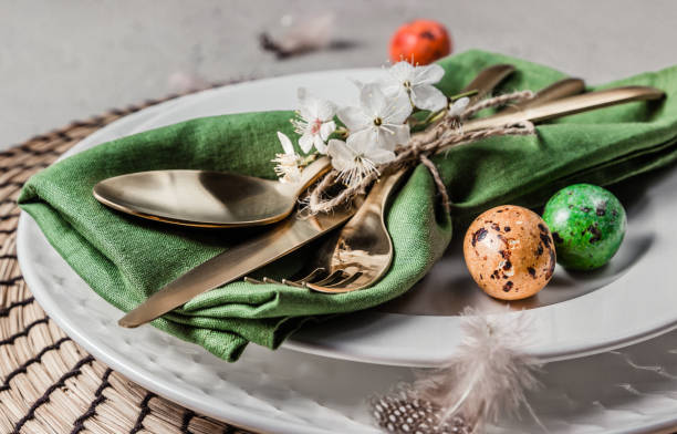 istock Easter table setting. Empty plates with green linen napkin and golden cutlery on concrete background. Top view. Flat lay. Copy space. 1216224094