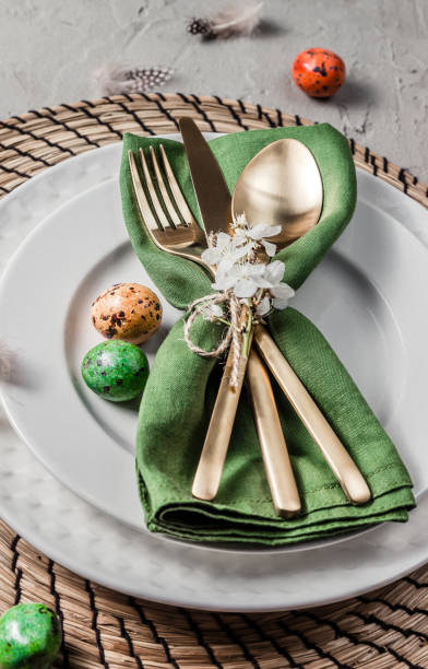 istock Easter table setting. Empty plates with green linen napkin and golden cutlery on concrete background. Top view. Flat lay. Copy space. 1216224103