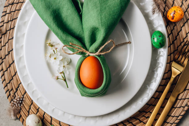 istock Easter table setting. Empty plates with green linen napkin and golden cutlery on concrete background. Top view. Flat lay. Copy space. 1216224110