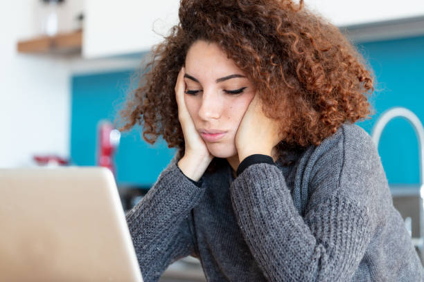 istock Fed up young woman working from home on laptop 1216225319