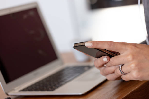 istock A young woman on a laptop using a smart phone 1216225698