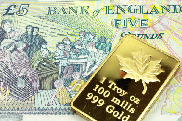 A colorful five pound note from the UK with a gold bar in macro stock photo