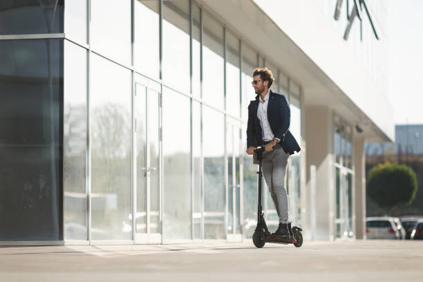 Young businessman driving e-scooter in the city stock photo