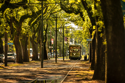 New Orleans, Louisiana - June 18, 2019:  Passengers ride the historic streetcar along Saint Charles Avenue in the Garden District of New Orleans Louisiana USA.  The St. Charles Avenue line is the oldest continuously operating street rail system in the world.