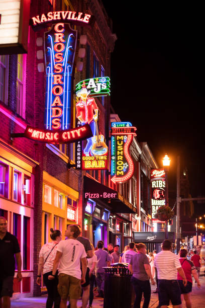 Neon signs along the Broadway in downtown Nashville Tennessee USA Nashville, Tennessee - June 20, 2019:  Colorful neon store signs hang along the bars restaurants and record stores along Broadway Street in downtown Nashville Tennessee USA tennessee photos stock pictures, royalty-free photos & images