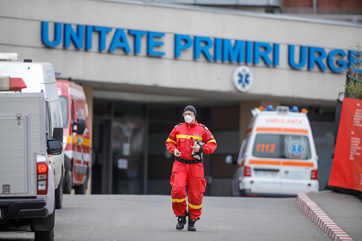 Bucharest, Romania - April 1, 2020: Romanian medical personnel wearing protective suits in the yard of a hospital closed for Covid-19 infection.