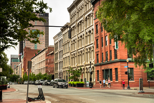 Louisville, Kentucky - June 22, 2019:  Cars and people walk along main Street by the stores and buildings of downtown Louisville Kentucky USA.  Louisville is Kentucky's largest city and it sits on the Ohio River along the Indiana border.