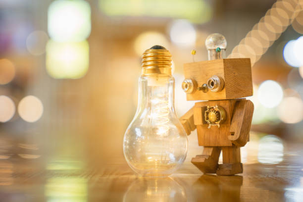Retro wood robot hold light bulb with two hand with bokeh light background,, nature power energy concept.