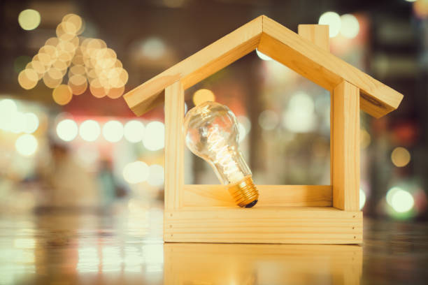istock Light bulb with wood house on the table, a symbol for construction, Creative light bulb idea, power energy or business idea concept ecology, loan, mortgage, property or home. 1216237541