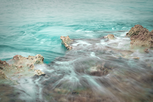 Surreal seascape with rocks and hazy waters, long exposure
