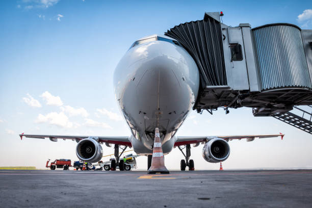 biały samolot pasażerski na moście odrzutowym i jest ładowany z bagażem - luggage ramp zdjęcia i obrazy z banku zdjęć