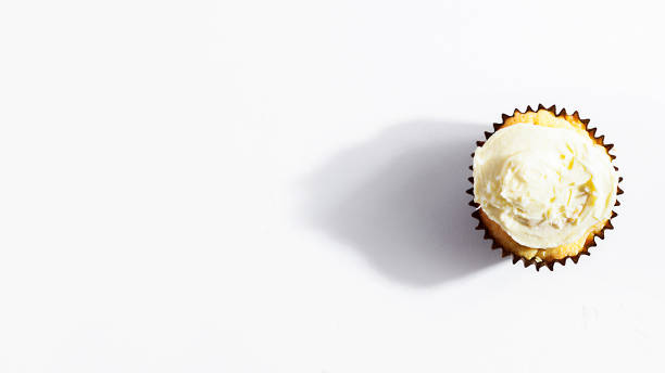 Coconut cupcake with white whipped vanilla icing cream on white background