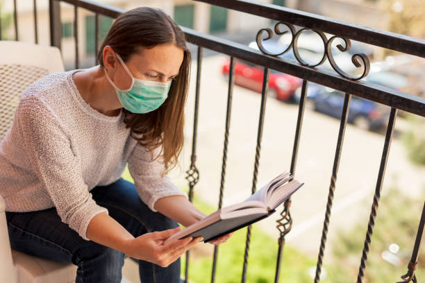 istock Woman reading book in home isolation 1216243852