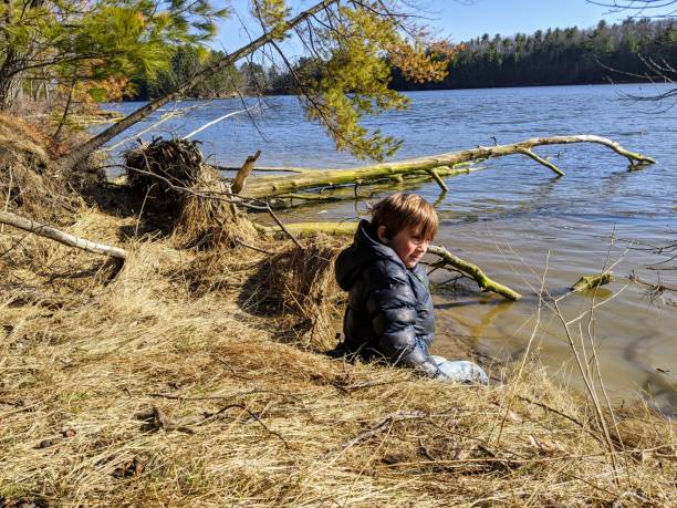 istock Boy sitting on riverbank 1216243865