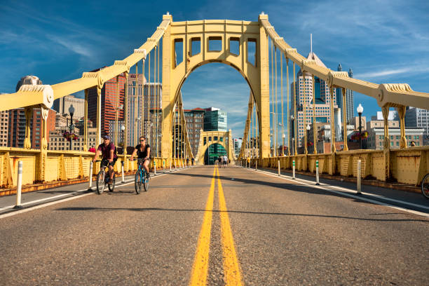 Downtown skyline and the Roberto Clemente Bridge in Pittsburgh Pennsylvania USA Pittsburgh, Pennsylvania - June 23 2019:  People walk and bike across the Allegheny River on the Roberto Clemente Bridge in downtown Pittsburgh Pennsylvania USA sixth street bridge stock pictures, royalty-free photos & images