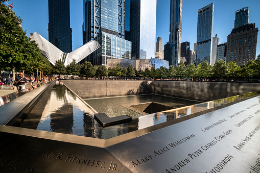 Manhattan, New York - September 17, 2019:   People visit One World Trade Center and the 911 memorial park and museum in lower Manhattan New York City USA