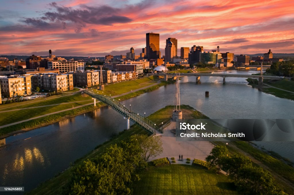 Colorful Cityscape Sunset An aerial drone view over a park looking towards downtown Dayton, Ohio at sunset at the confluence of the Great Miami and Mad Rivers with brightly colored clouds in the sky. Ohio Stock Photo